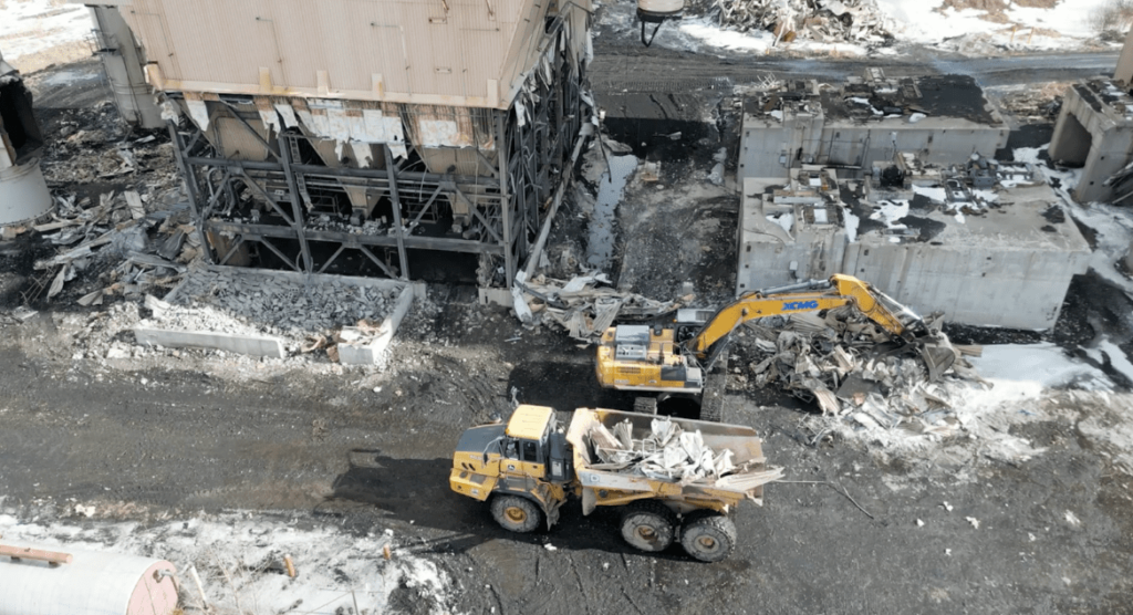 Dump truck and excavator working on demolition site